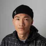 Kai, a procurement lead wearing a beanie in a casual office