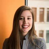 Sarah, a finance manager smiling in a corporate setting