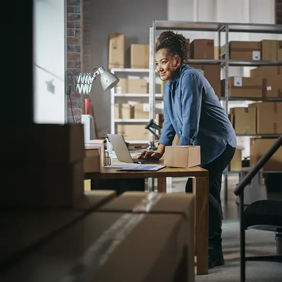 Warehouse team member checking stock and goods received records on a laptop