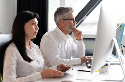 A business team discussing purchase approvals on a digital dashboard in Business Central