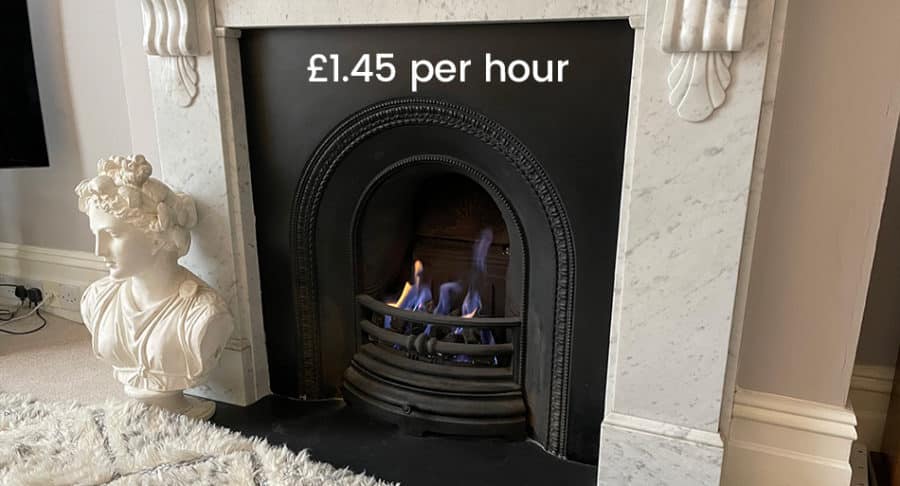 A marble fireplace with a small fire burning, a white bust statue on the left, and the text "£1.45 per hour" displayed above the fire.
